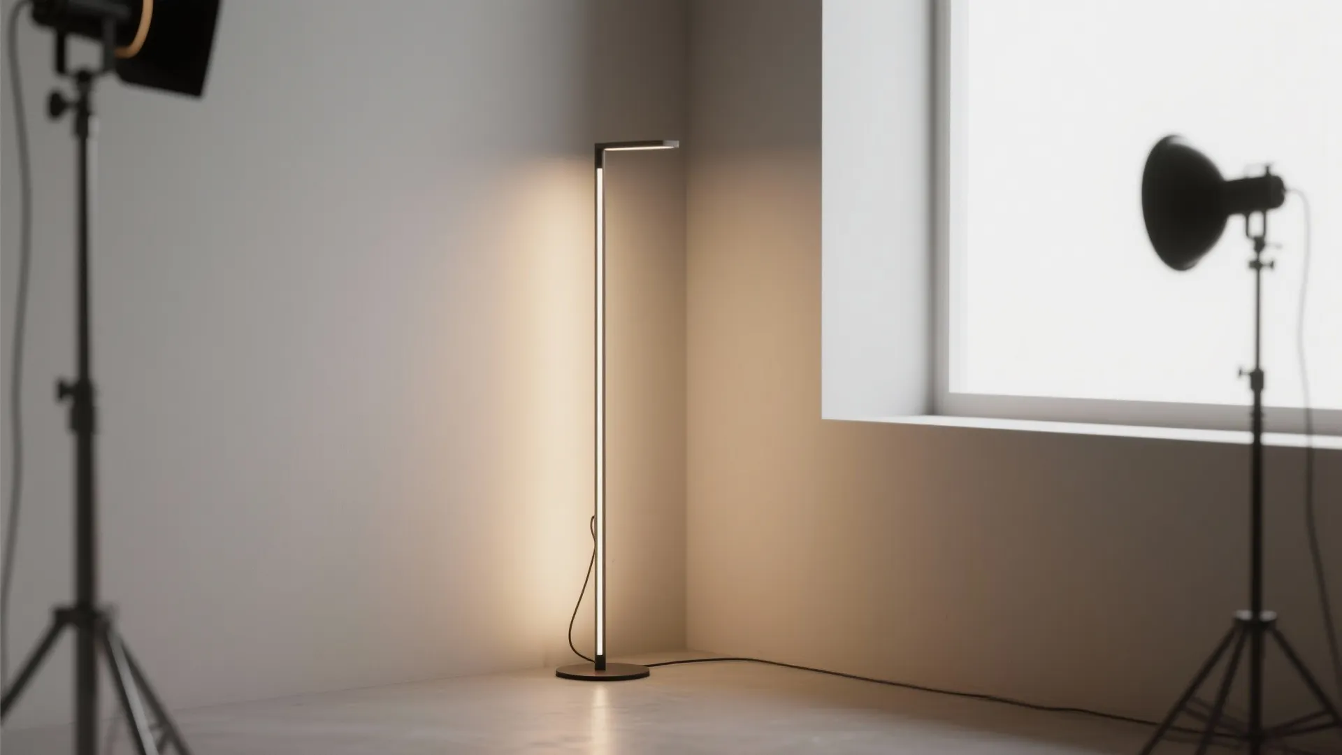 Slim freestanding floor lamp with hidden uplight in a small studio corner