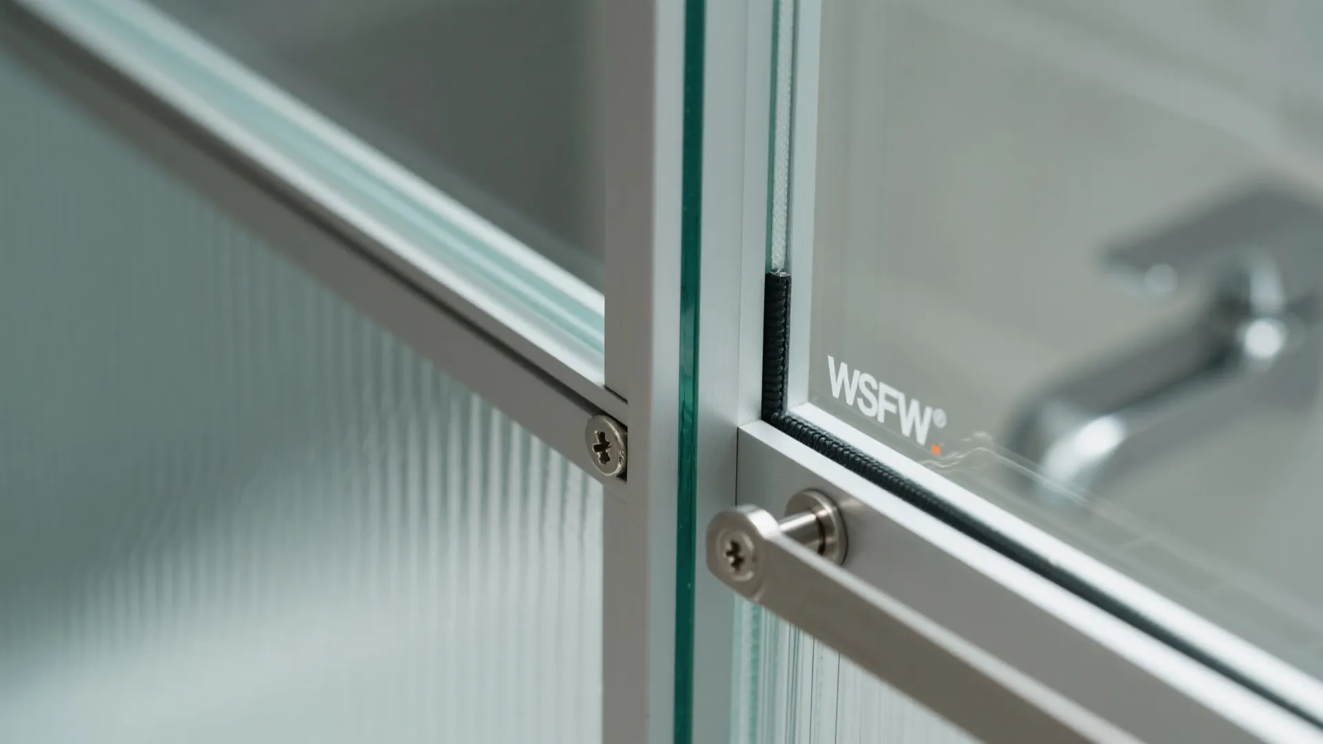Macro of frosted tempered glass door corner with anodized aluminum frame and EPDM gasket.