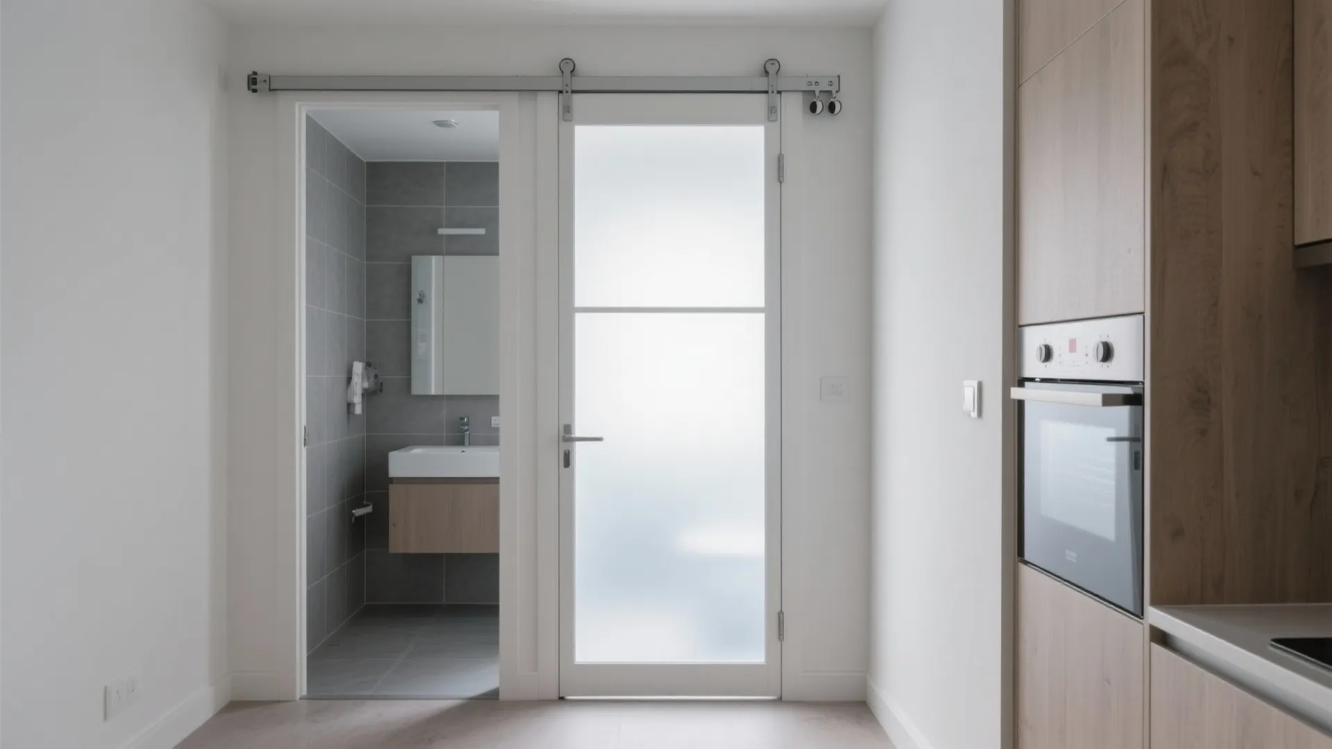 Modern white sliding glass door with frosted glass panel leading into a grey tiled bathroom