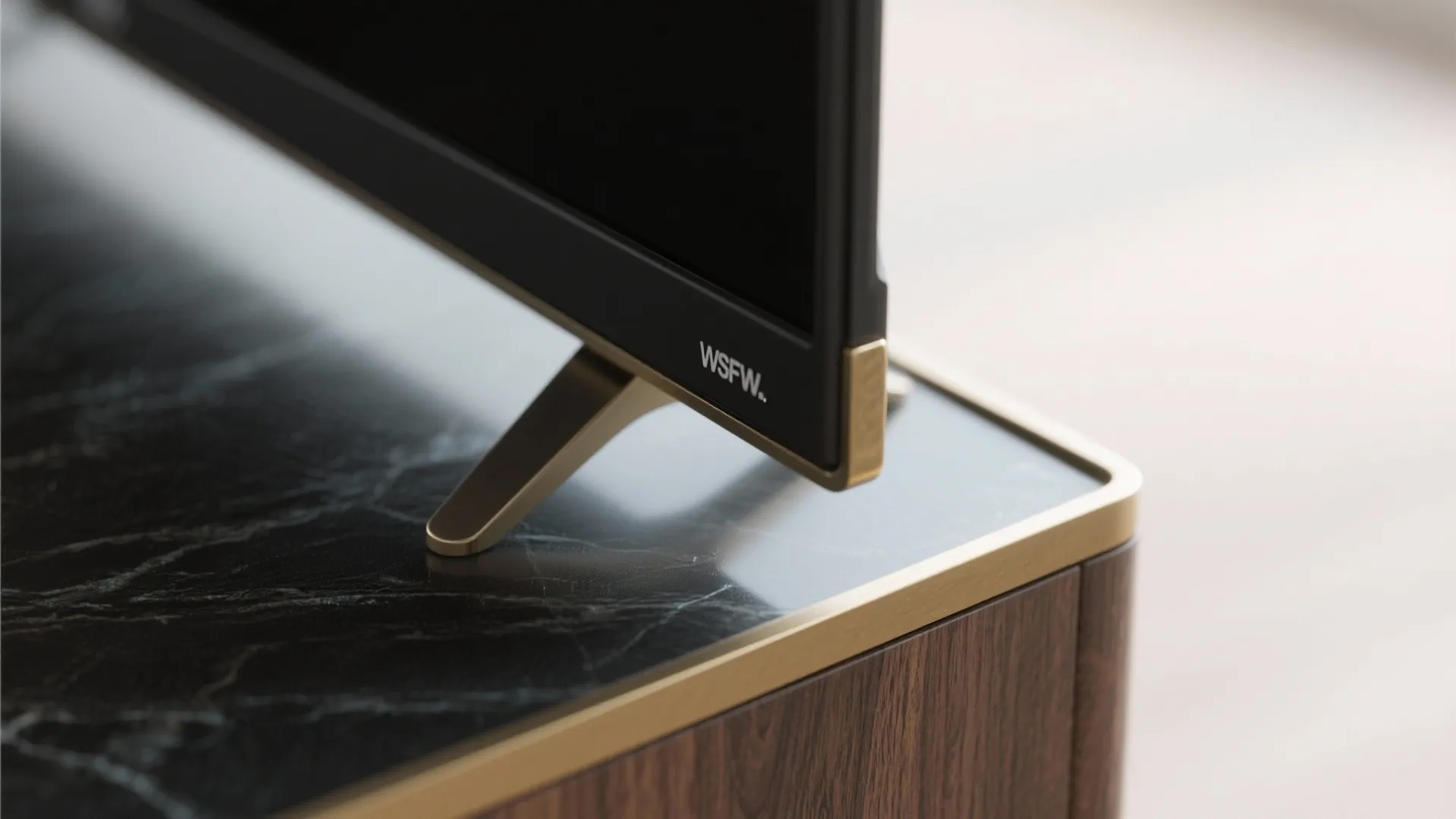 Macro of matte frame and brass accent near the small TV showing reduced glare and fine texture.