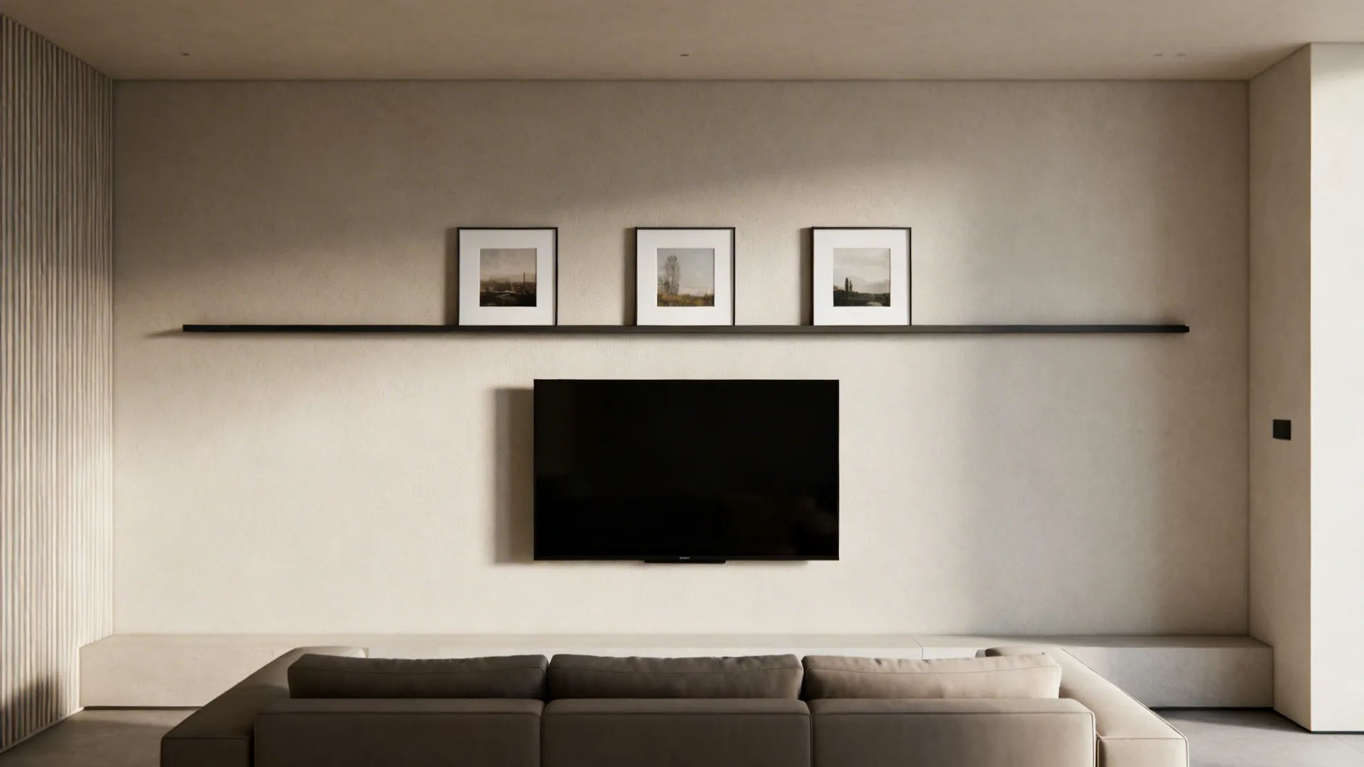 Living room view with wall mounted television and three small framed pictures on long shelf