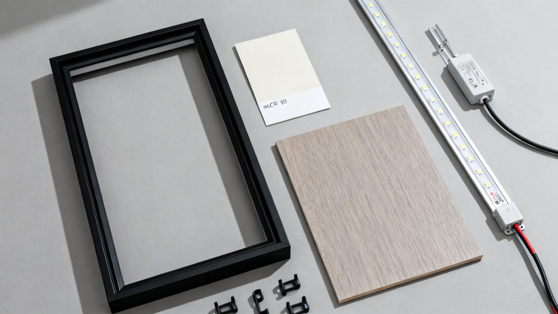 Flat lay of slim frame, high-CRI LED strip in aluminum channel, dimmer, and matte finish samples.
