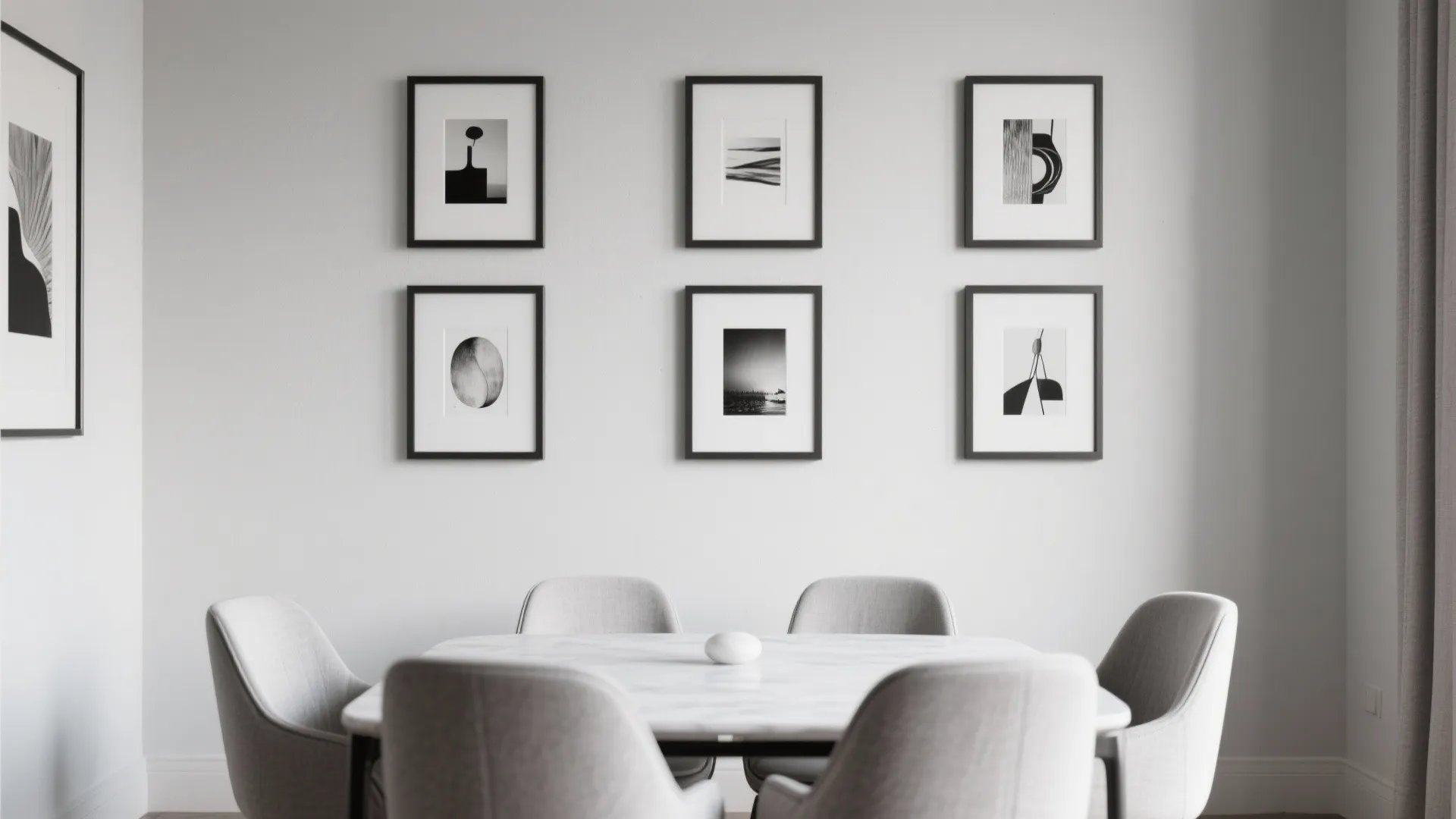 Modern dining room featuring marble table and grey chairs with black and white wall art