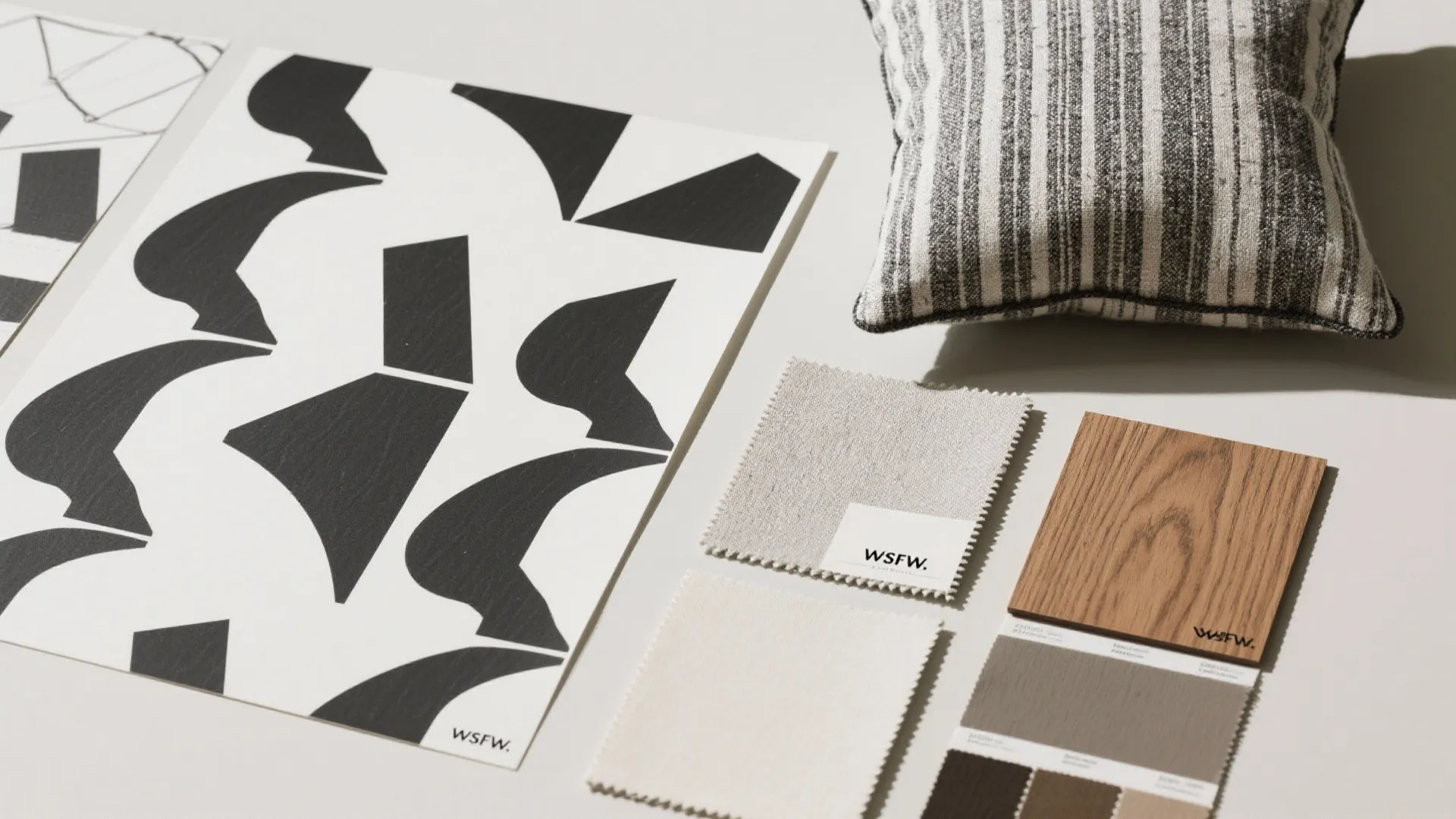 Interior design mood board with black geometric patterns striped pillow wood sample and fabric samples