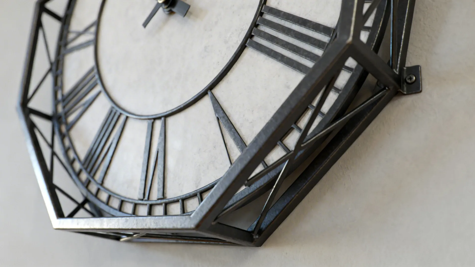Close-up of a geometric metal-frame wall clock with architectural lines and matte finish
