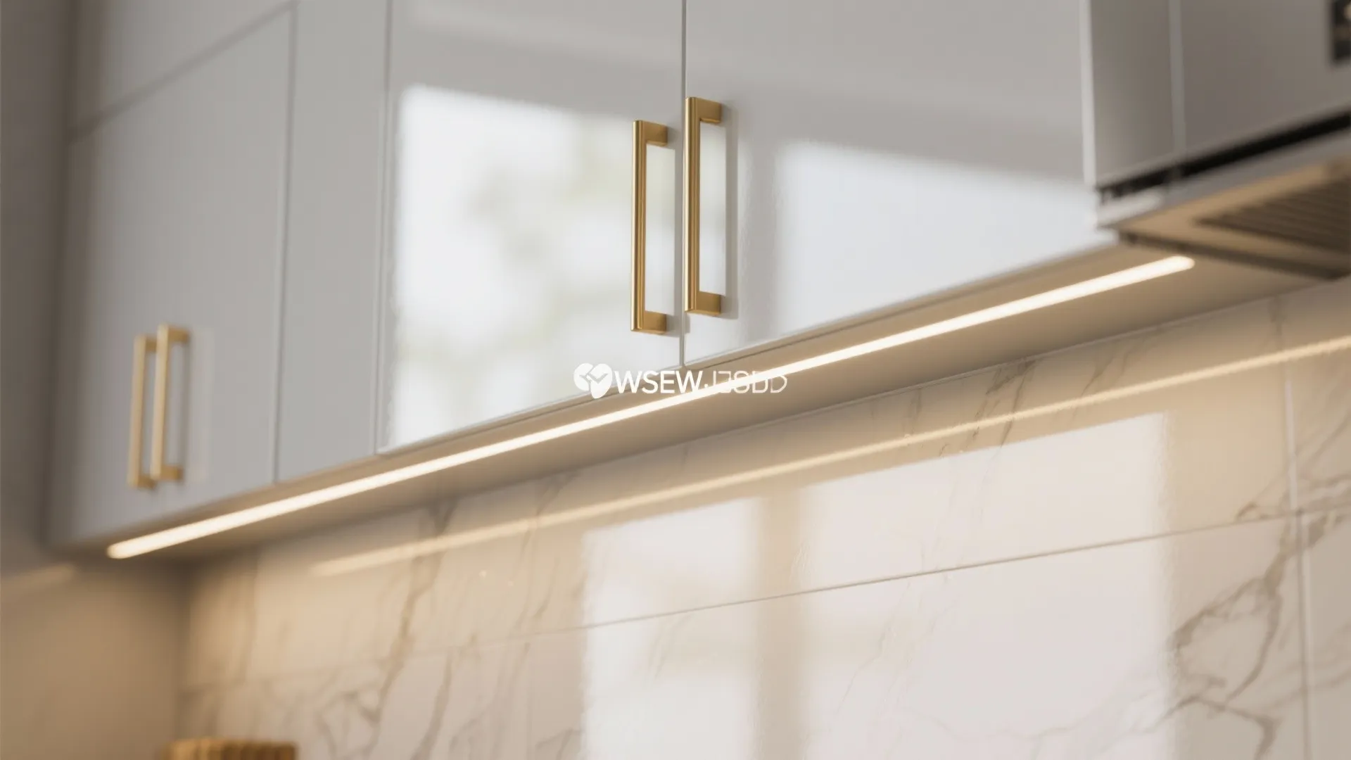 White kitchen cabinets with gold handles and light strip above a white marble wall background
