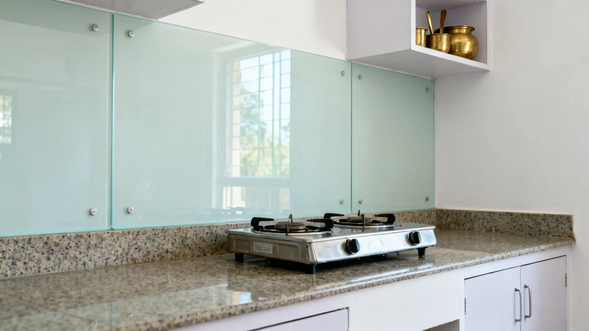 Wide-angle view of a small kitchen with a light-tinted tempered glass backsplash that brightens the space.