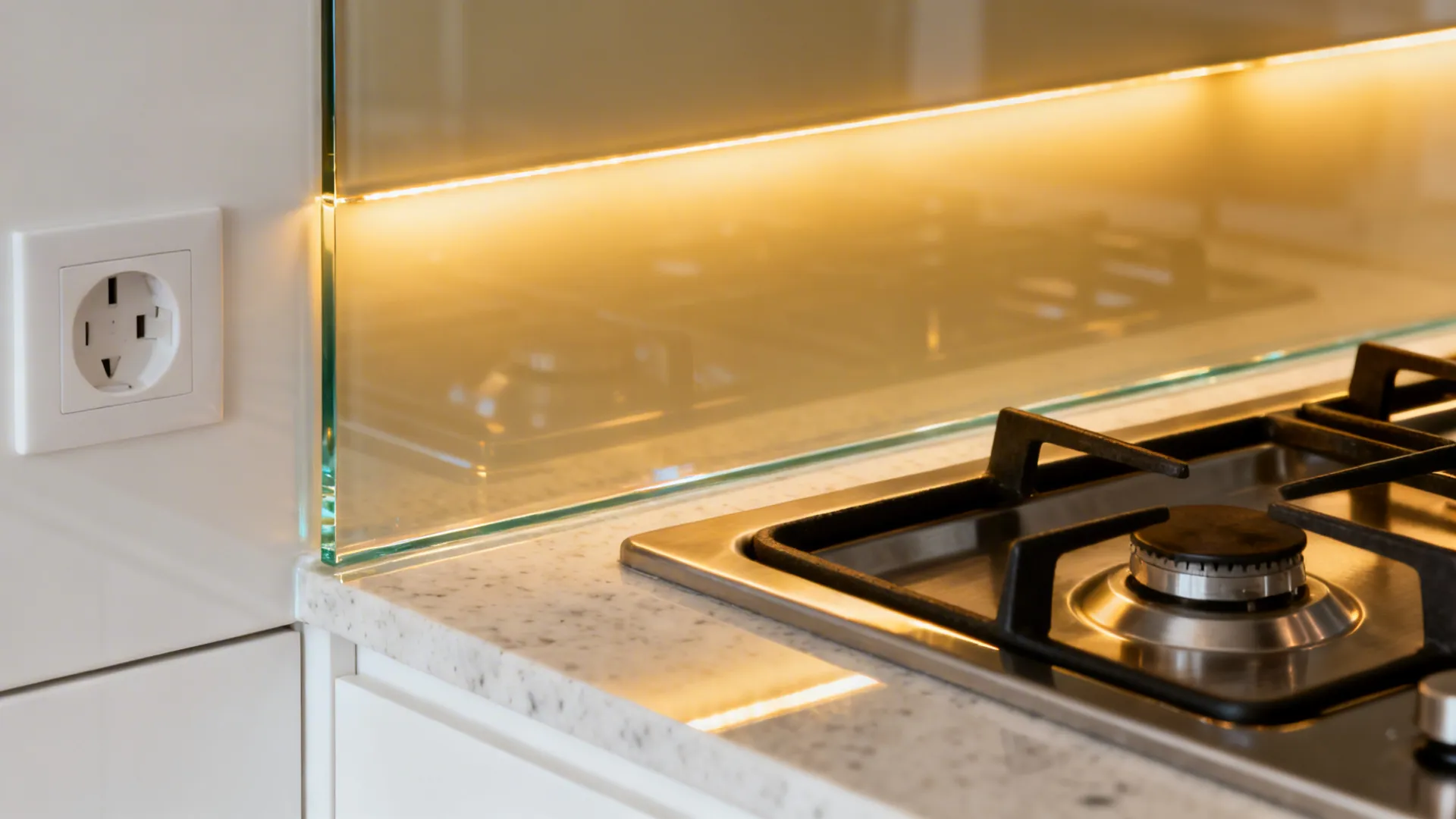 Macro of low-iron back-painted glass backsplash with polished edge and outlet cutout.