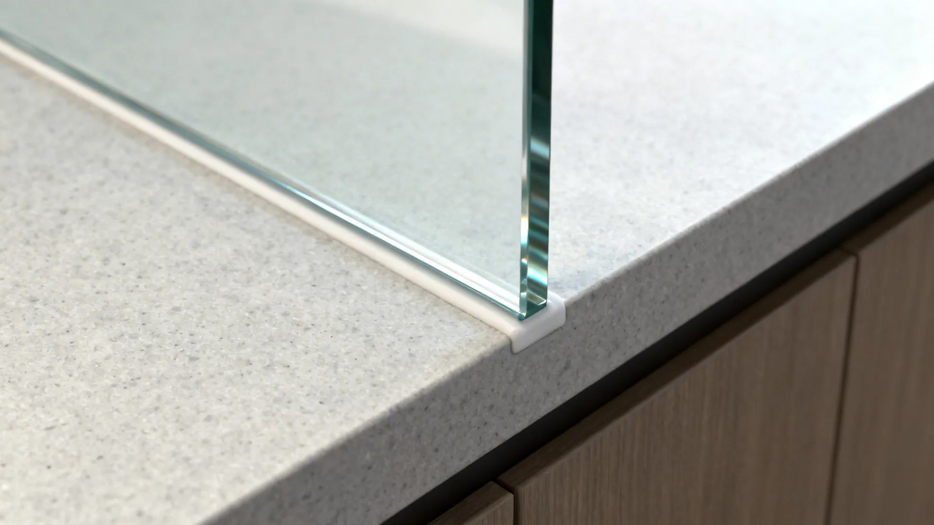 Macro of tempered glass backsplash meeting quartz countertop with crisp joint.