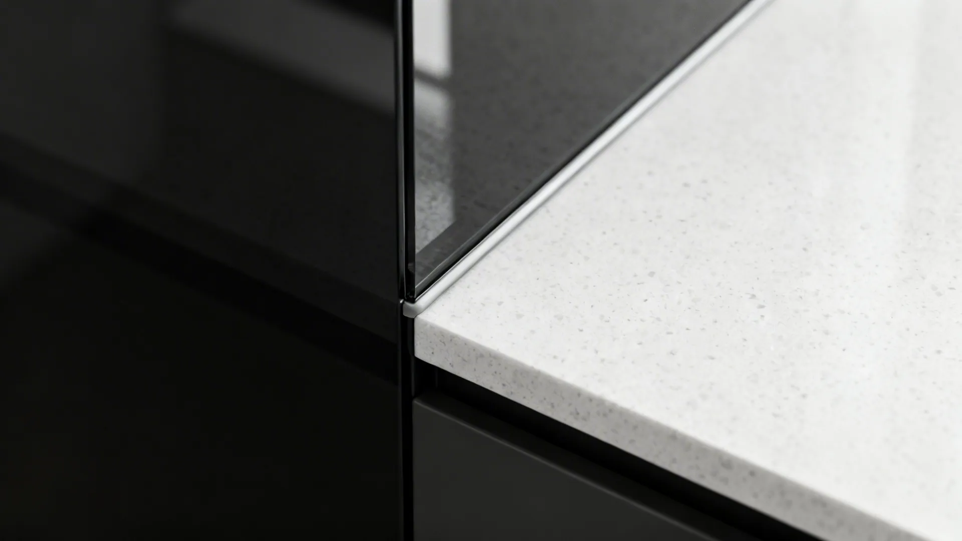 Macro view of black tempered glass meeting a light quartz counter with a clean joint.