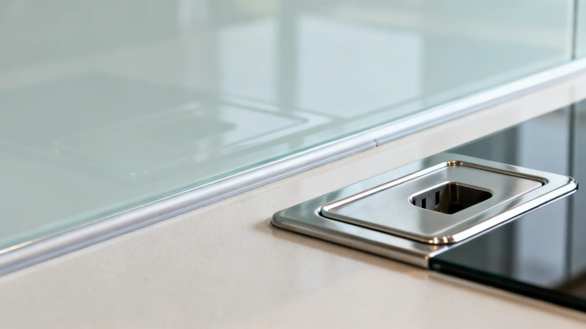 Close-up of polished edge and silicone reveal on a back-painted glass backsplash.