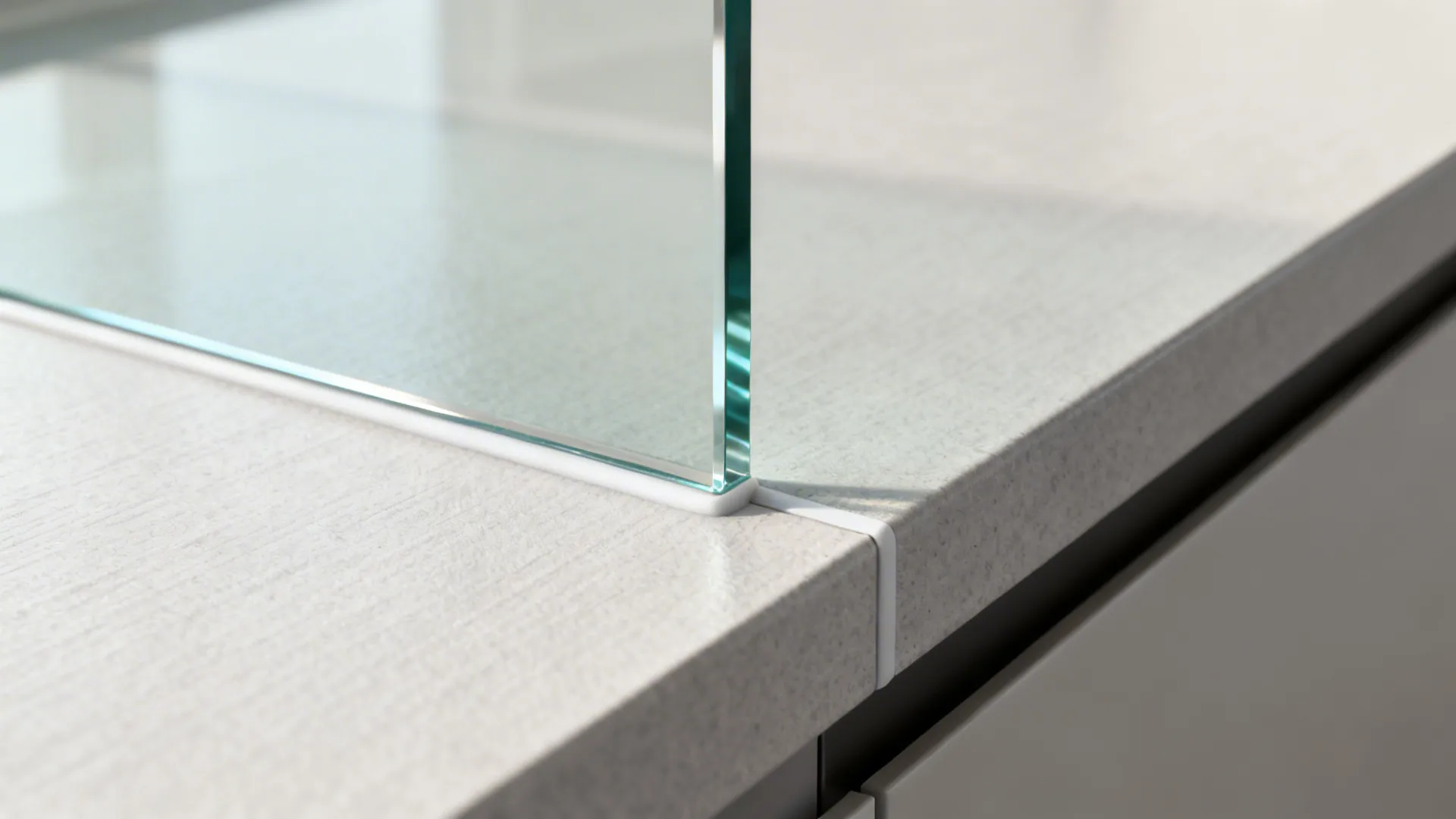 Macro detail of low-iron glass backsplash edge and clean joint above a laminate countertop.