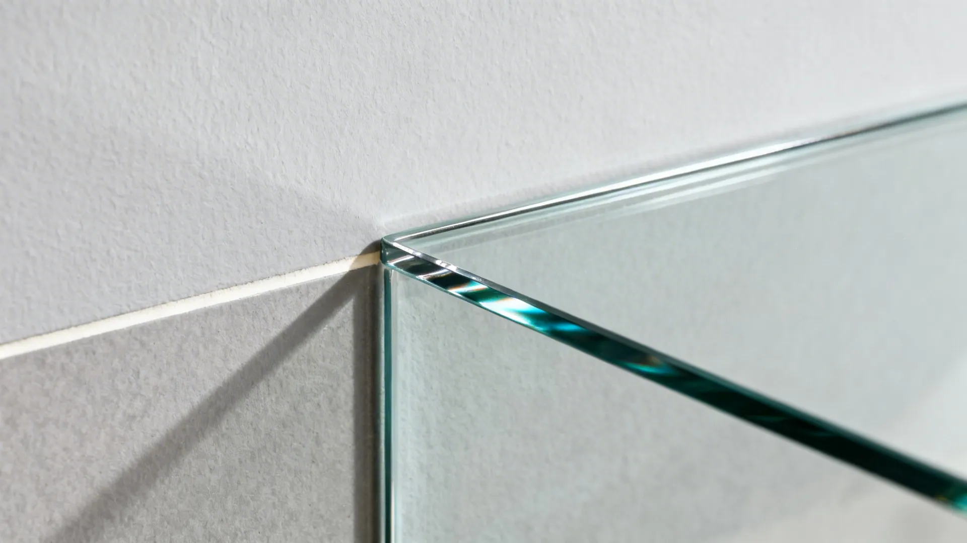 Close-up of low-iron glass backsplash edge with subtle reflection and clean finish.