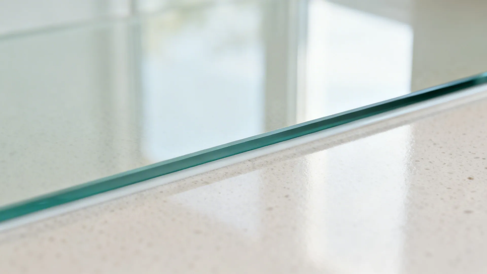 Macro of a tempered glass backsplash edge with neat color-matched silicone.