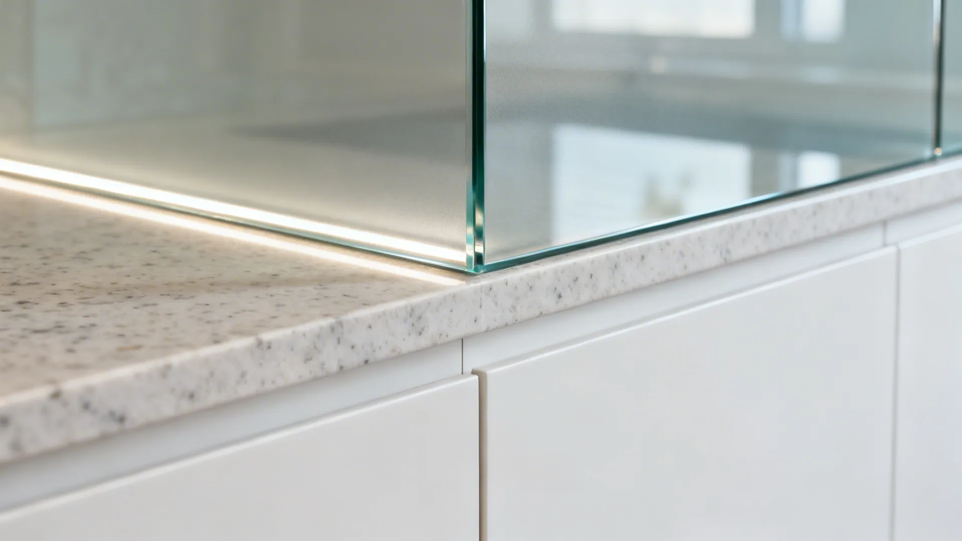 Close-up of low-iron glass backsplash meeting quartz countertop with precise alignment.