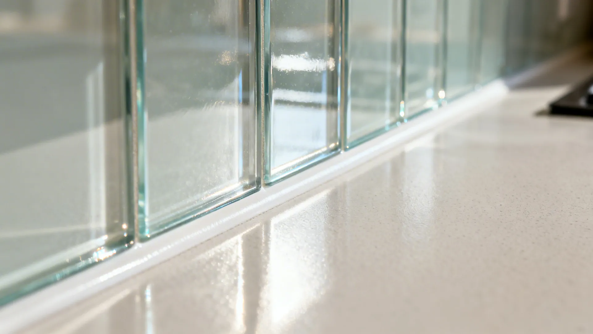 Macro of a glass backsplash edge with subtle reflections and clean transitions.