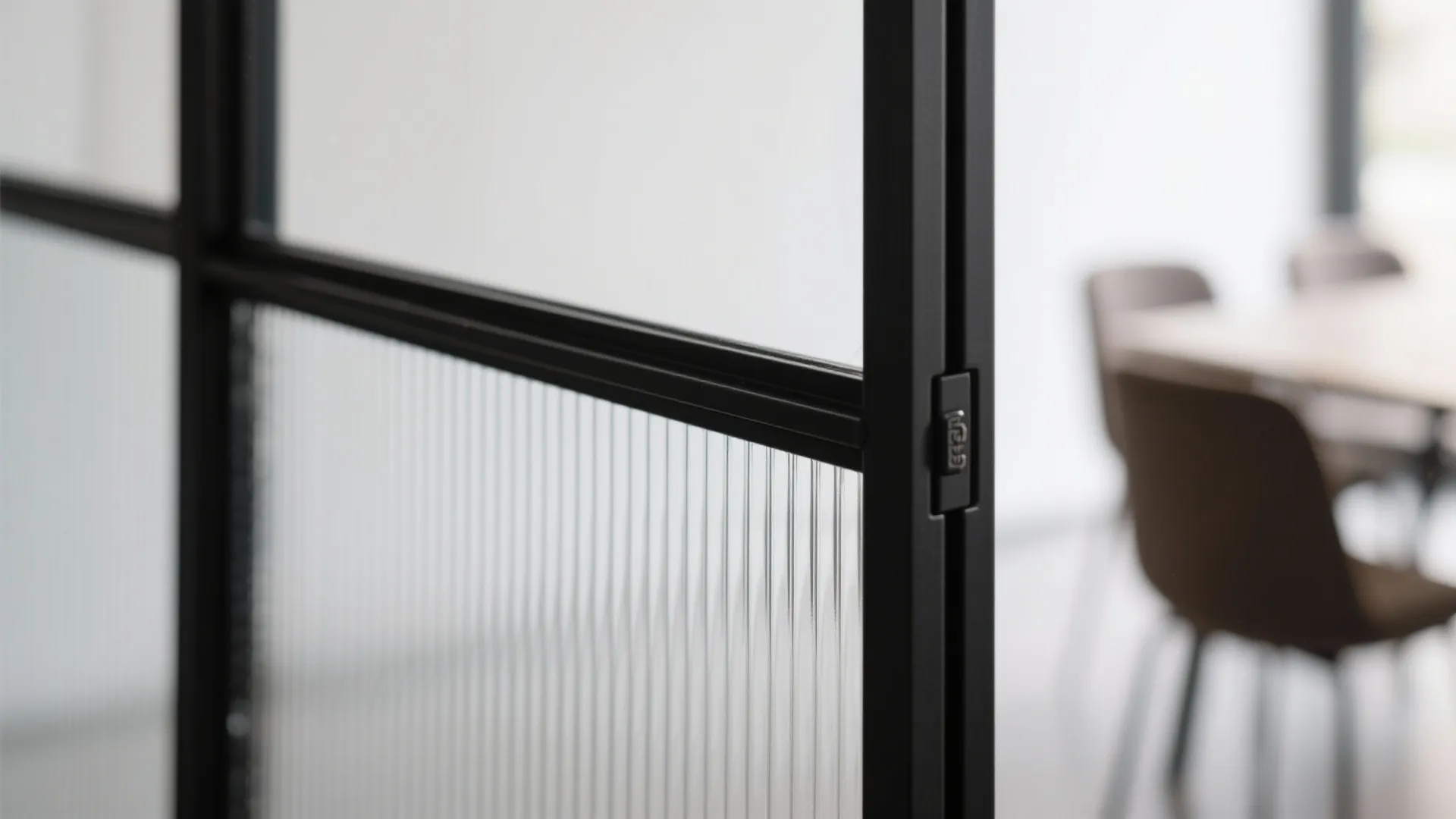 Black metal frame glass door with ribbed texture detail in a modern office room setting