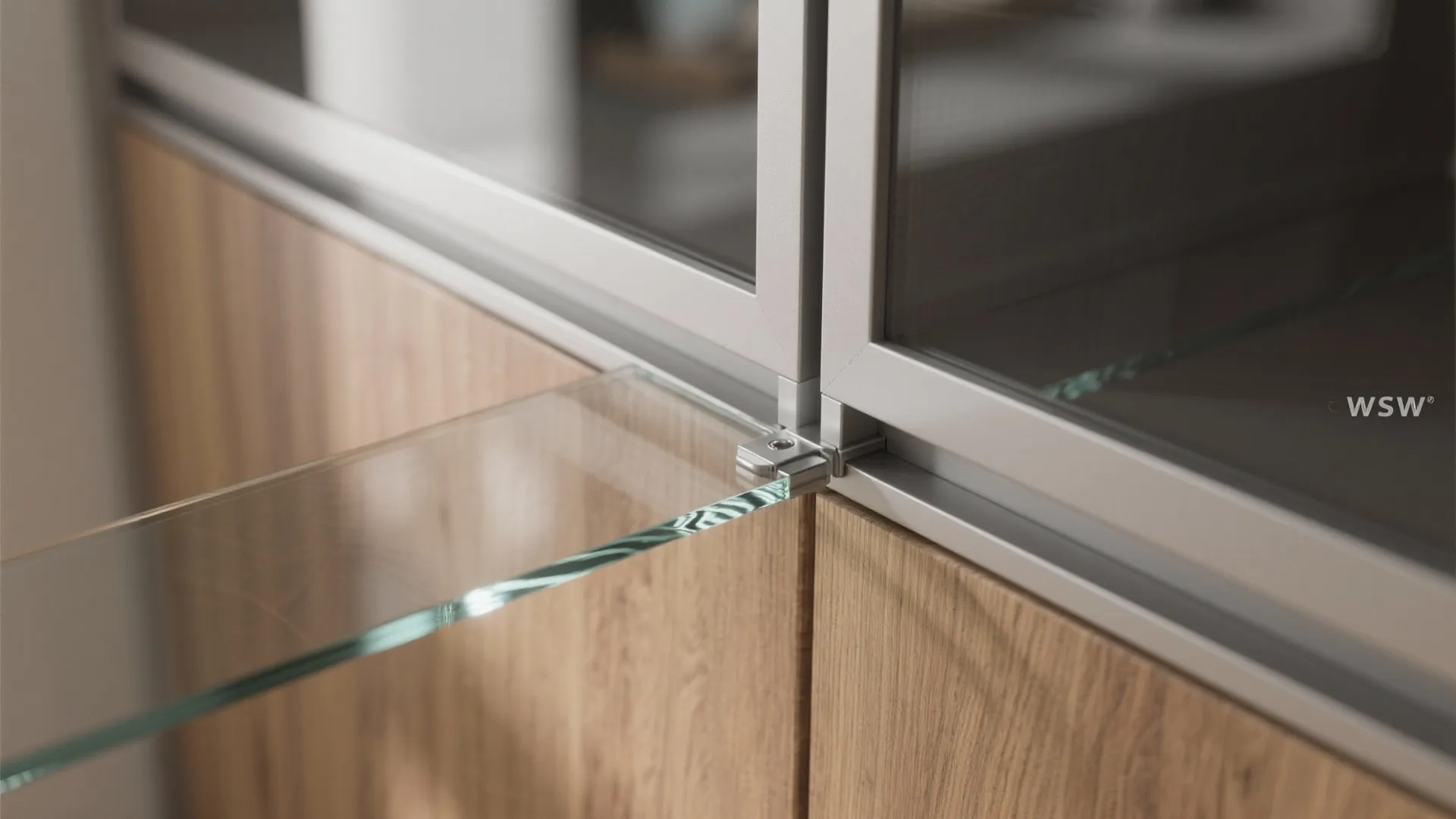 Close up view of a glass shelf corner attached to a wooden cabinet with metal frames