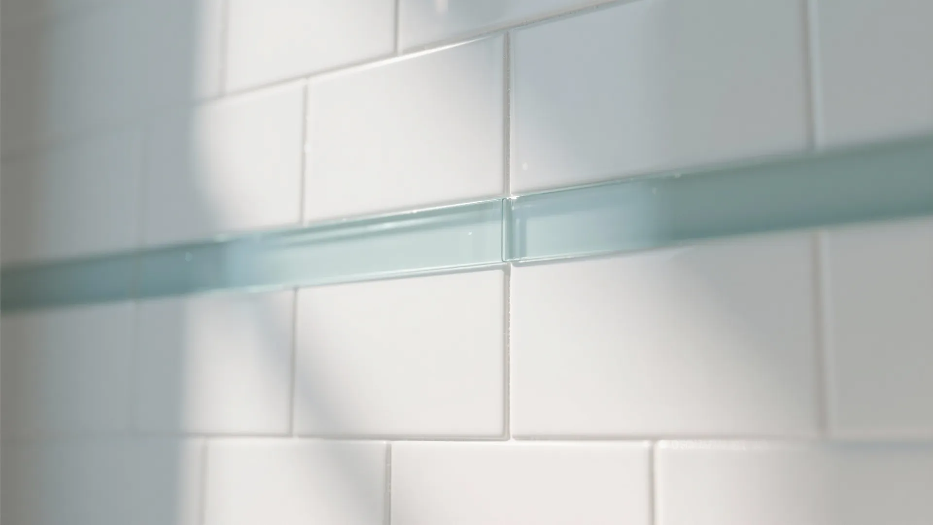 Close up view of white wall tiles with a decorative light blue glass strip line