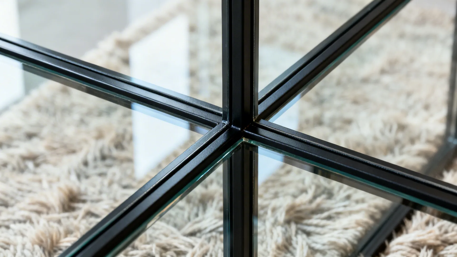 Macro of black steel mullion with low-iron tempered glass showing clean edges and reflections.
