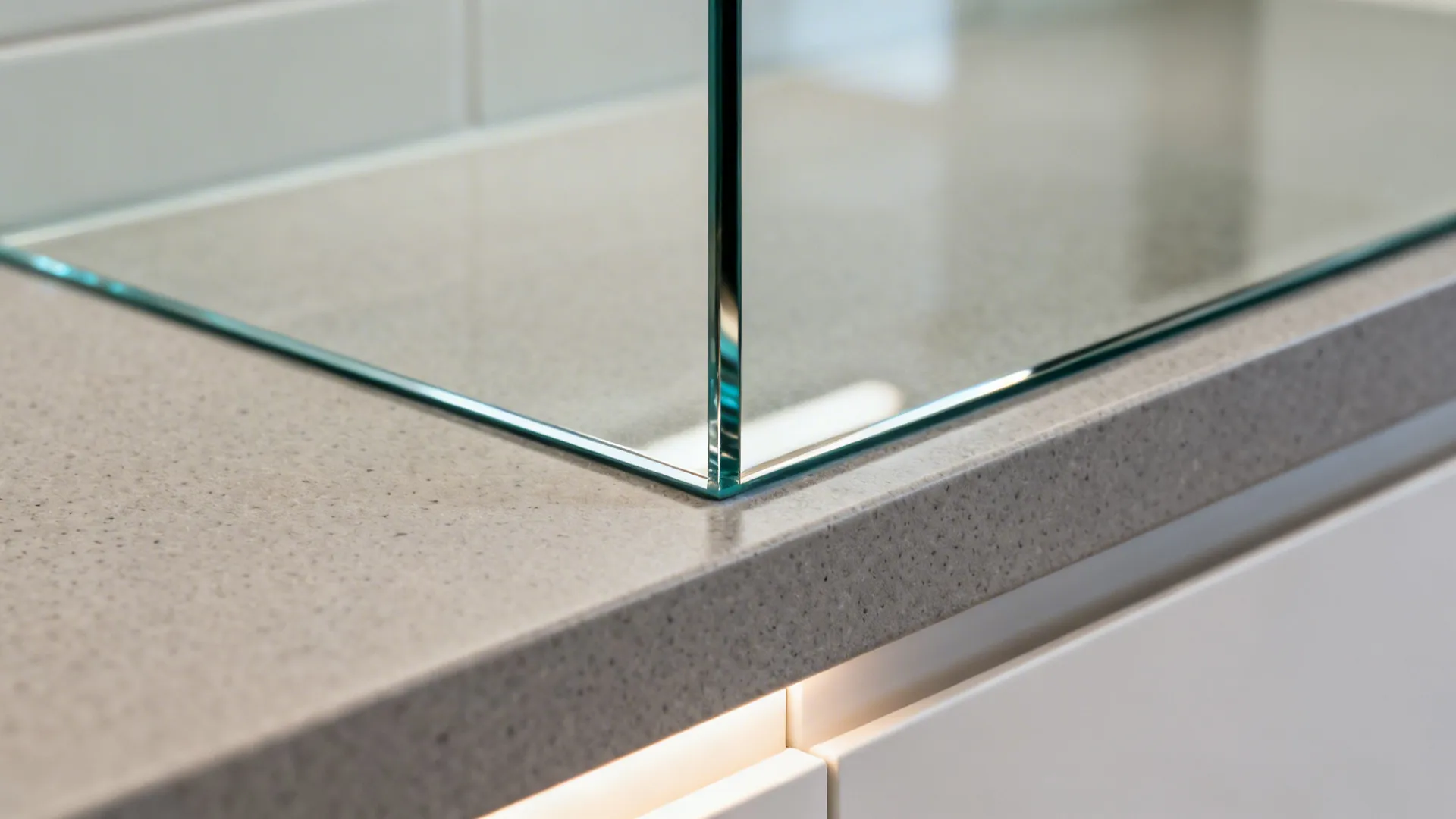 Macro of back-painted glass backsplash meeting a matte quartz countertop with soft LED glow.