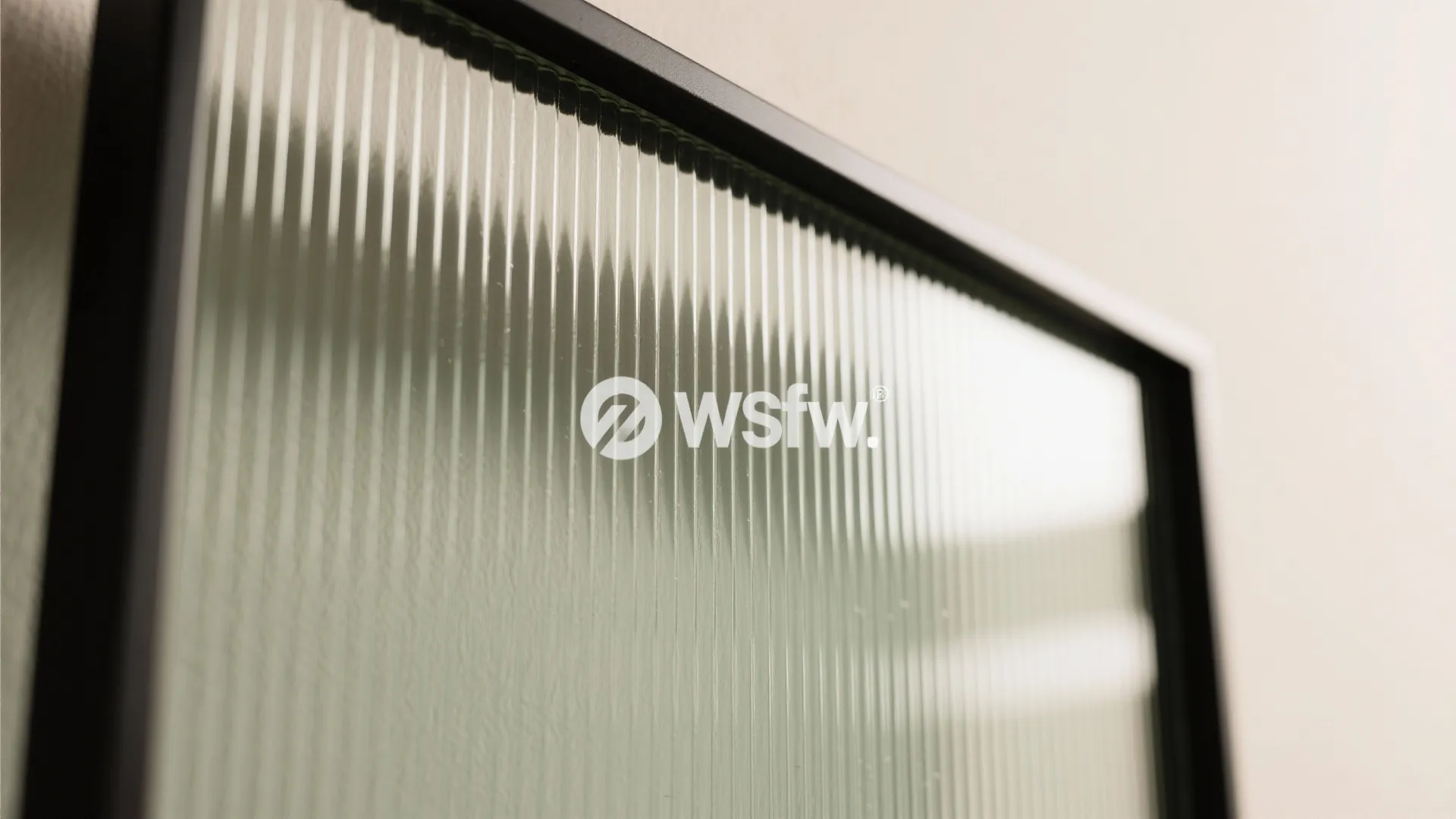 Close up of vertical textured glass panel inside a black metal frame for interior doors