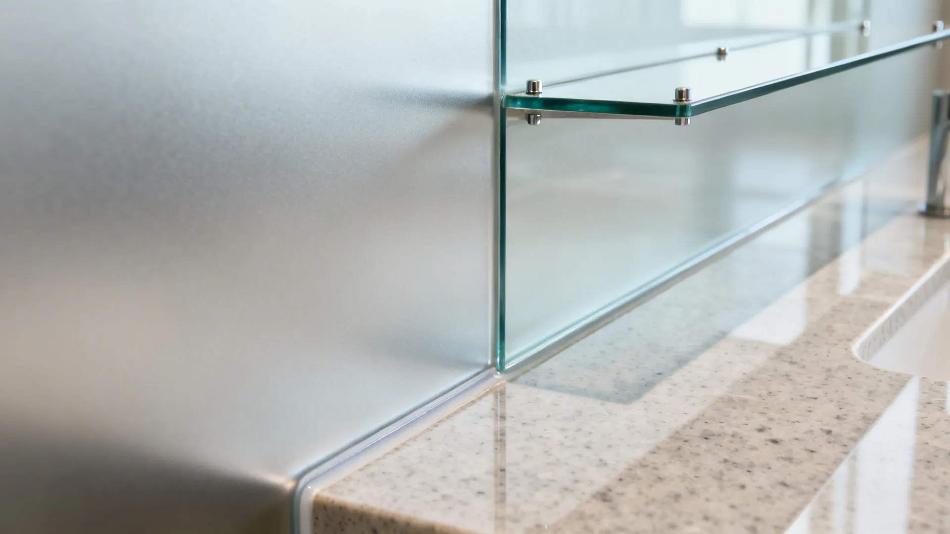 Macro of satin glass splash, quartz junction, and discreet shelf pins.