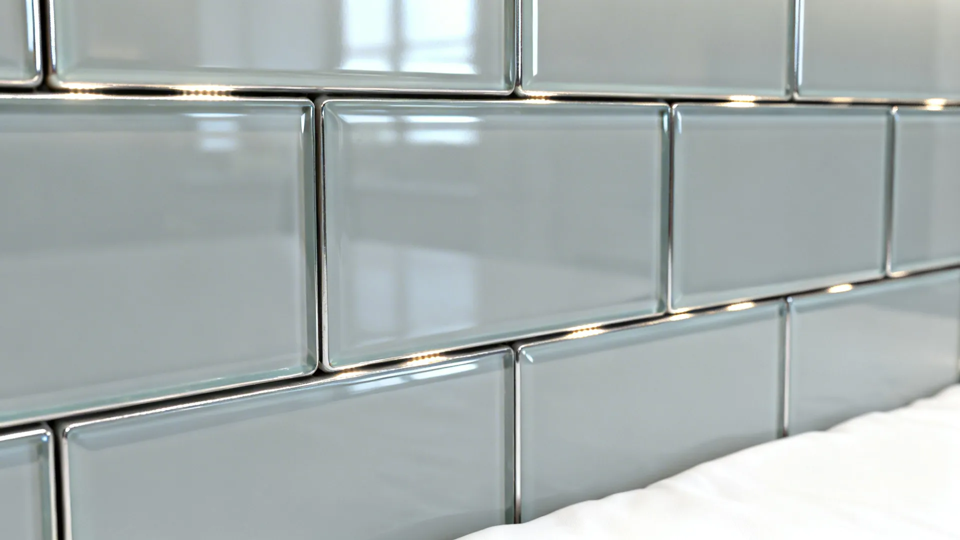 Close up shot of light grey glass wall tiles with glossy finish and clean grout