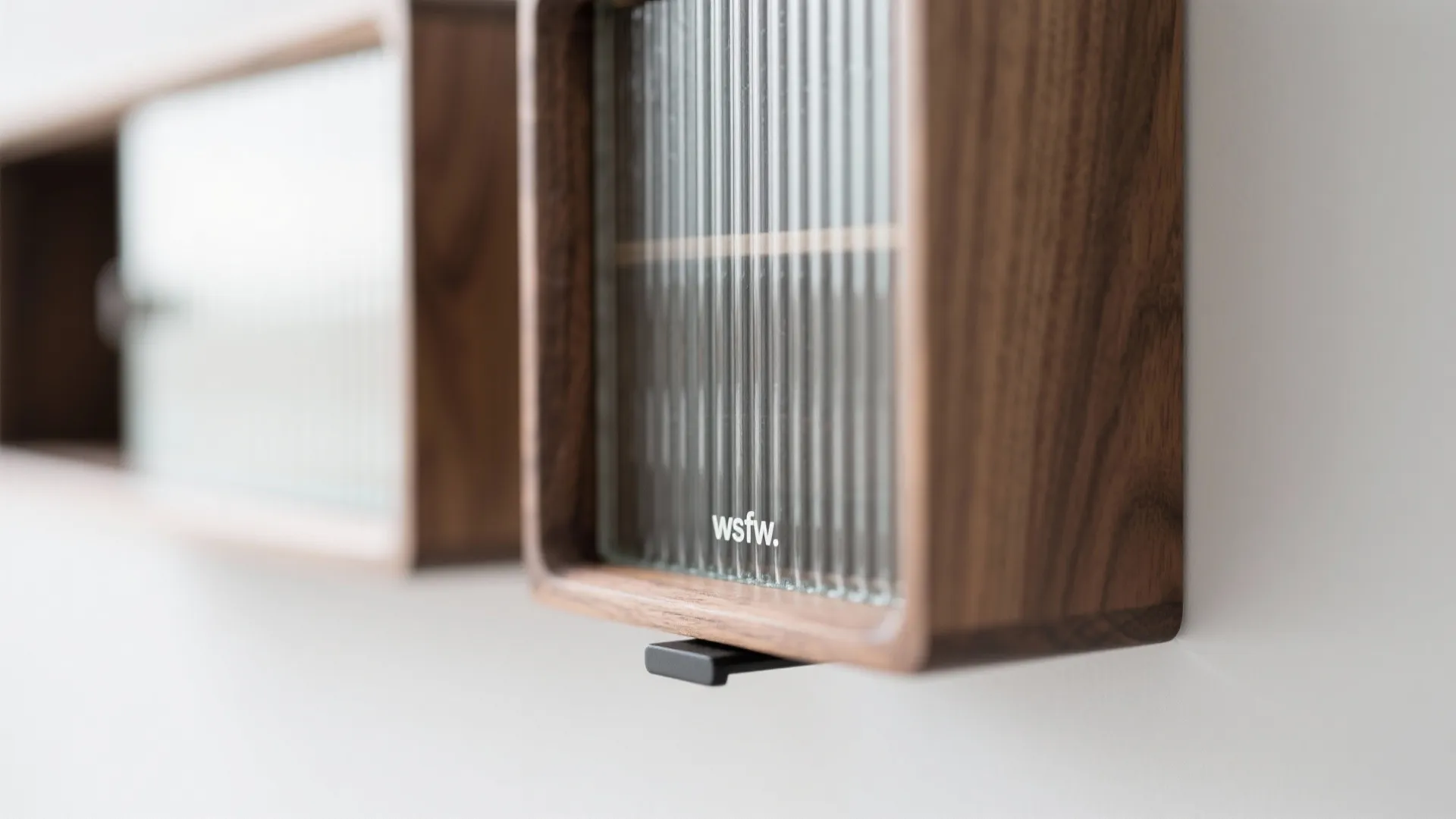 Close up of wall mounted wooden storage cabinets featuring textured glass doors in a room