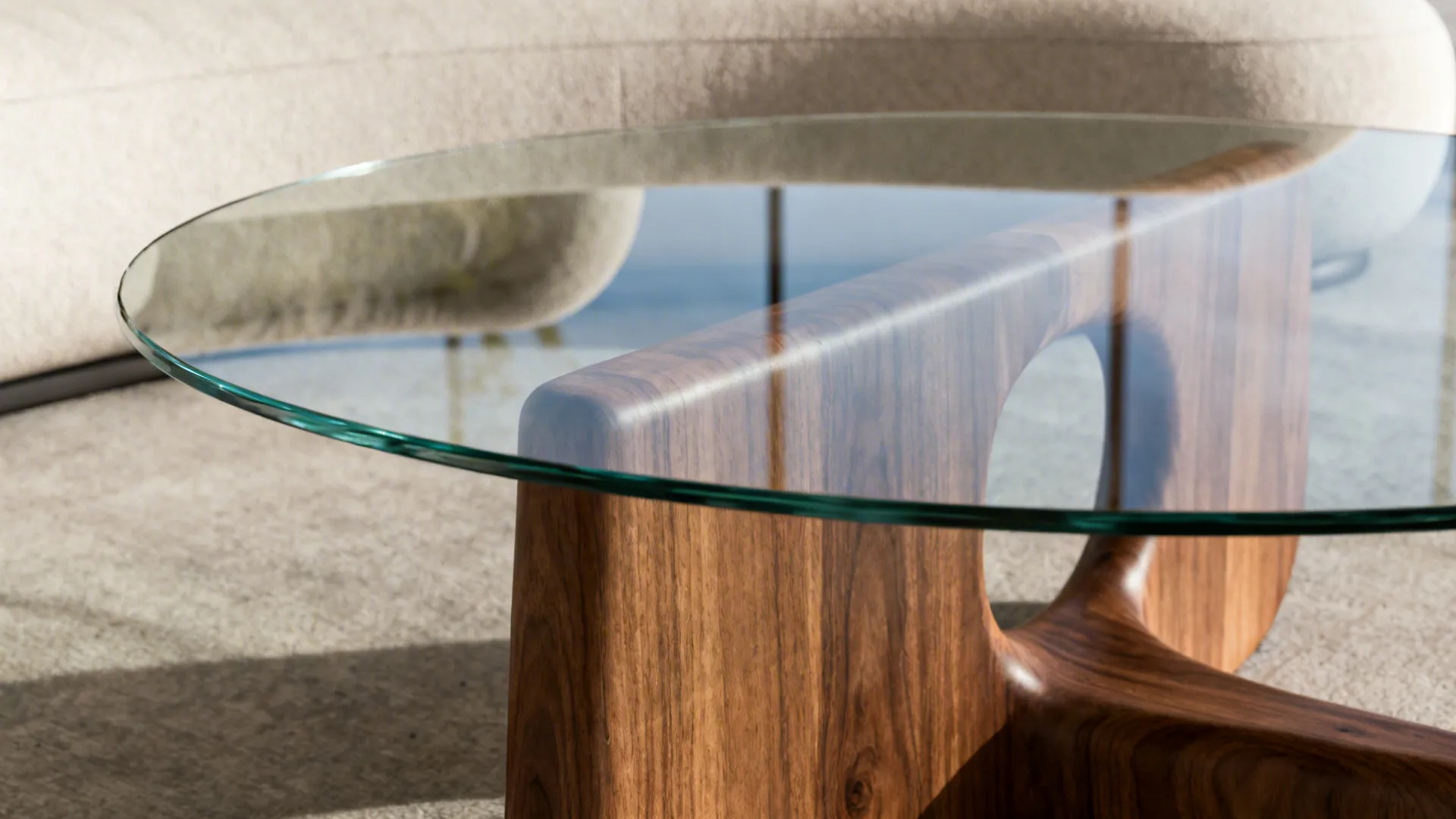 Round glass coffee table with curved dark wood base on carpet in modern living room