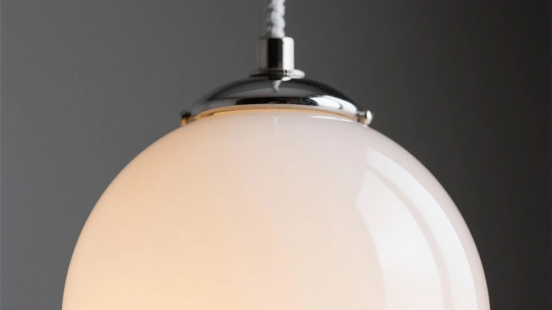 Macro detail of an opal globe pendant with warm diffused light and clean hardware.