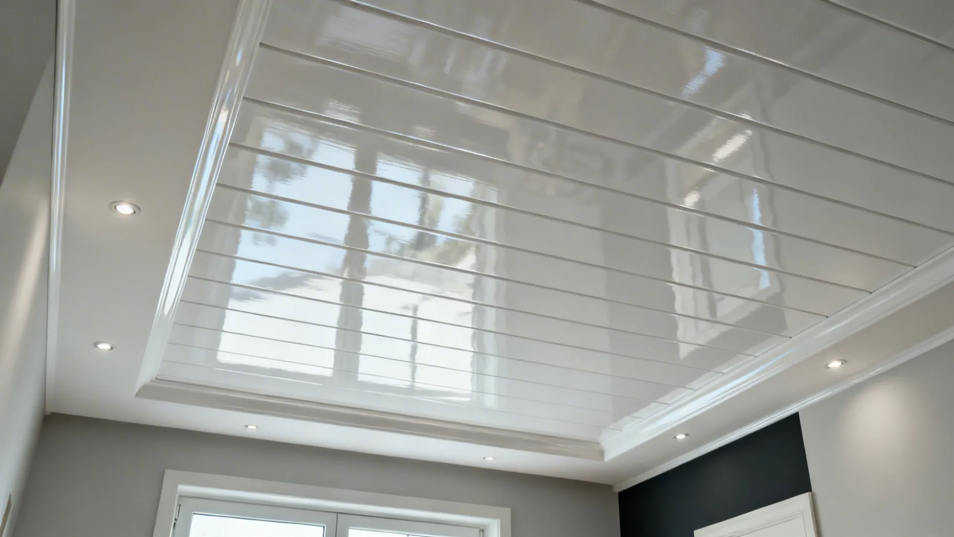 High-gloss pearl white PVC ceiling reflecting light in a compact living room with micro-spots.