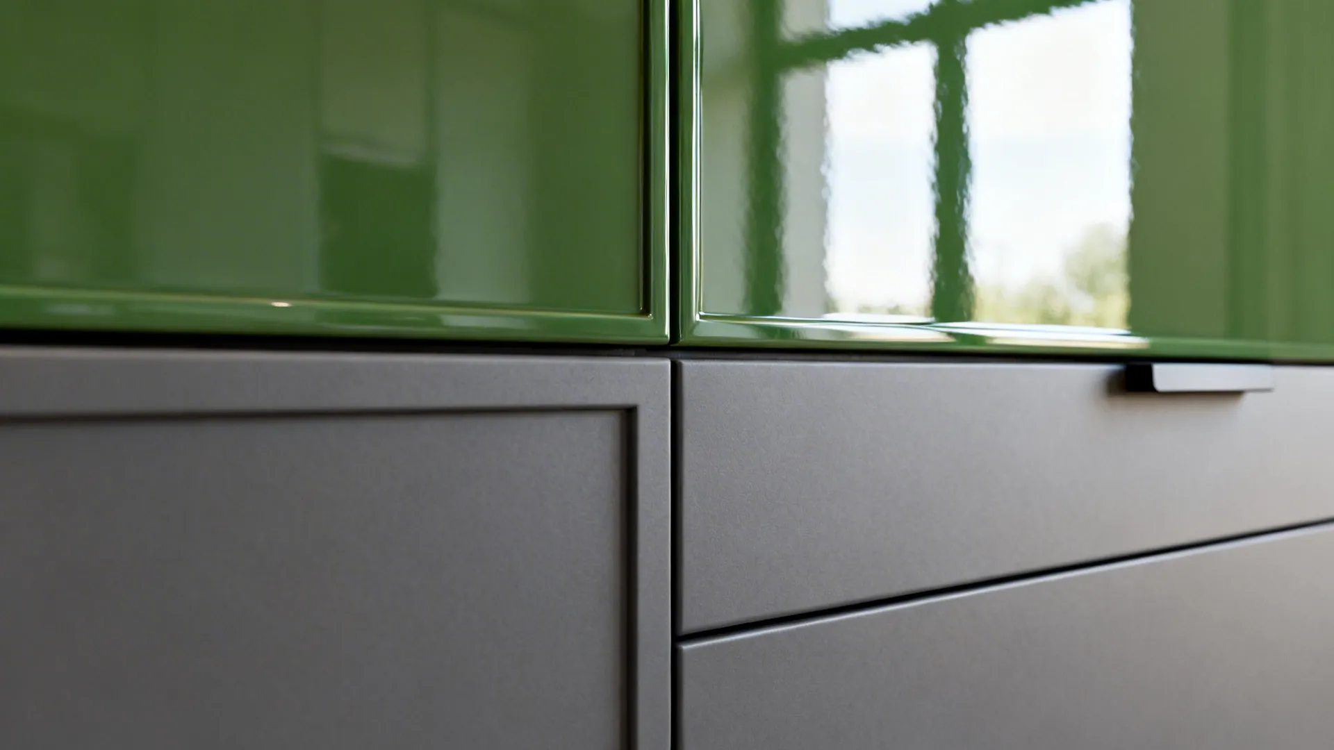 Close up showing shiny green upper cabinets and matte grey lower cabinets with small handle