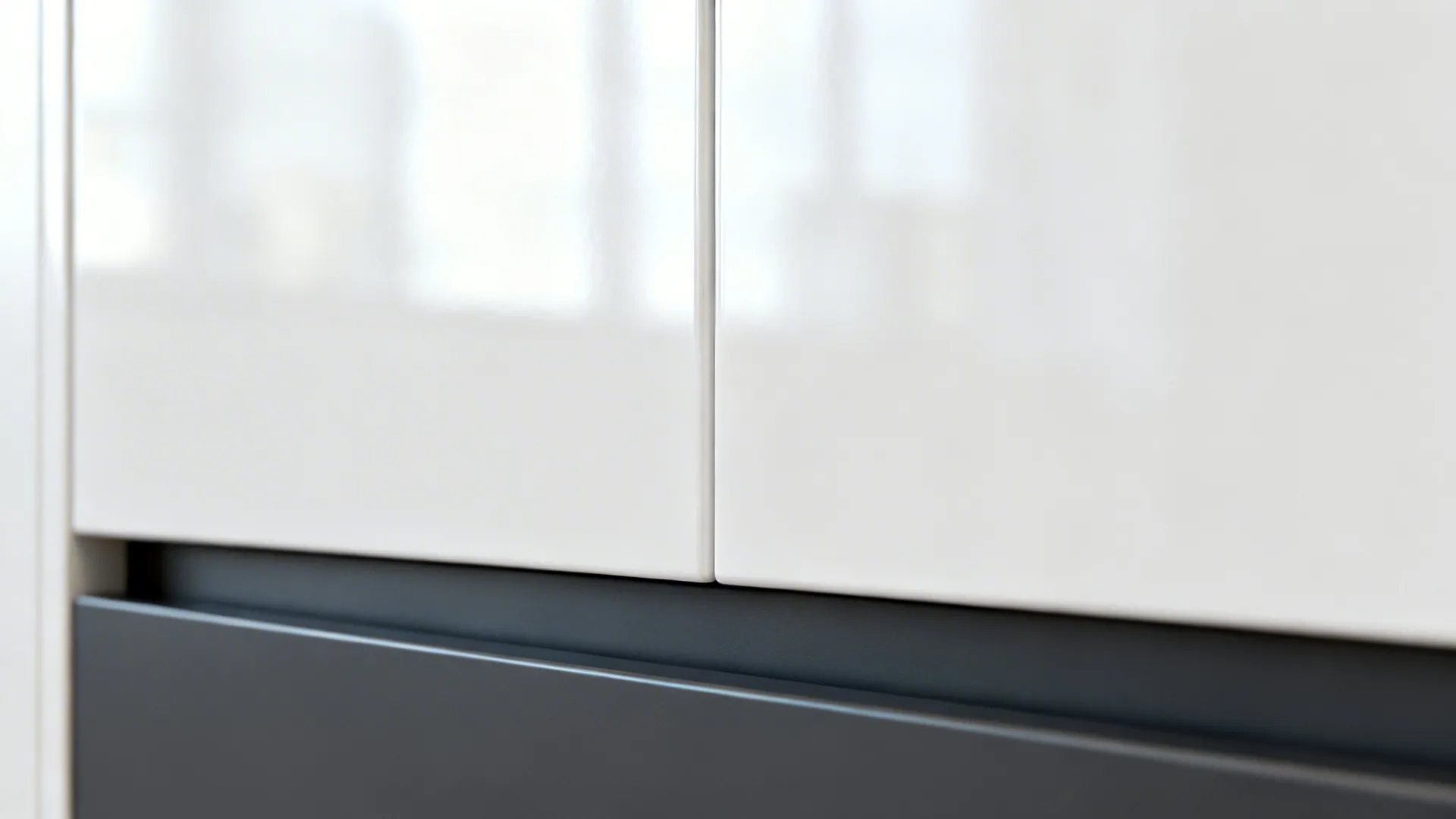 Macro of glossy white upper door and matte charcoal drawer with handle-less rail.