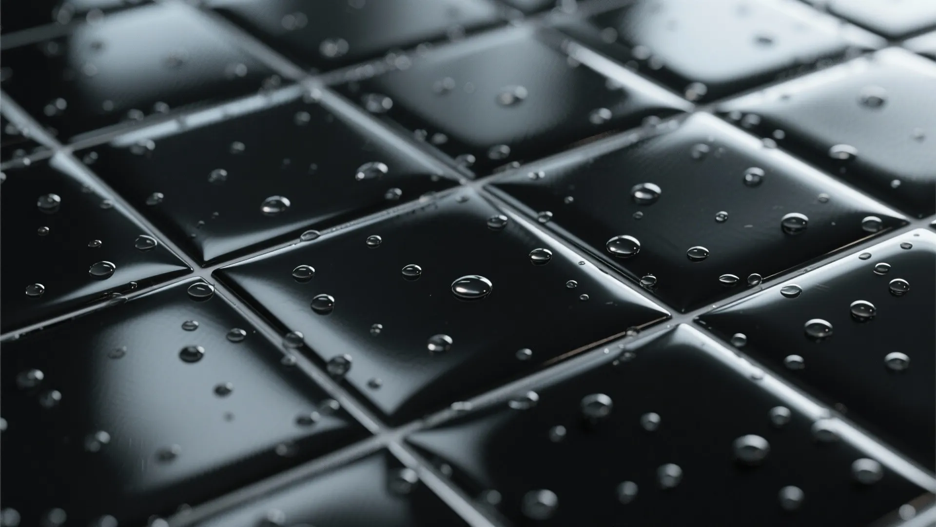 Close up of glossy black square tiles with many clear water droplets on the smooth surface
