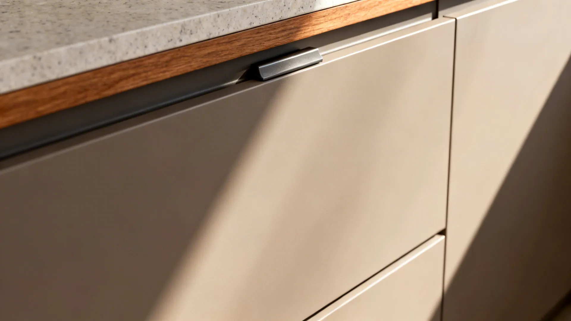 Macro of handleless Gola drawer with soft-close hardware and matte laminate texture.
