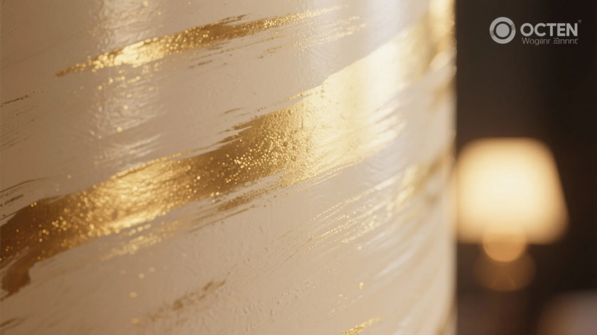 Close up view showing golden paint brush strokes on a white textured wall with light
