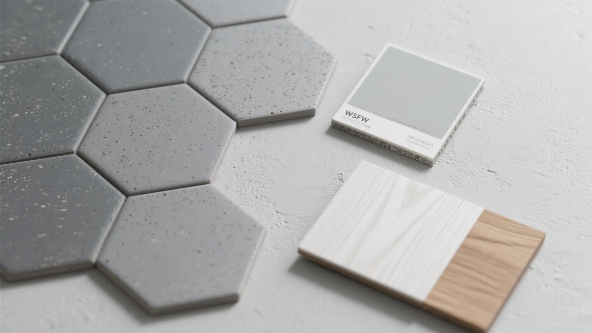 Flat lay with mid-gray hex tile, pale-gray paint, darker grout, and white oak veneer.