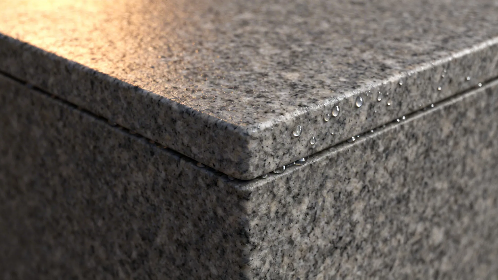 Macro of honed grey granite with subtle leathered texture and a crisp eased edge.