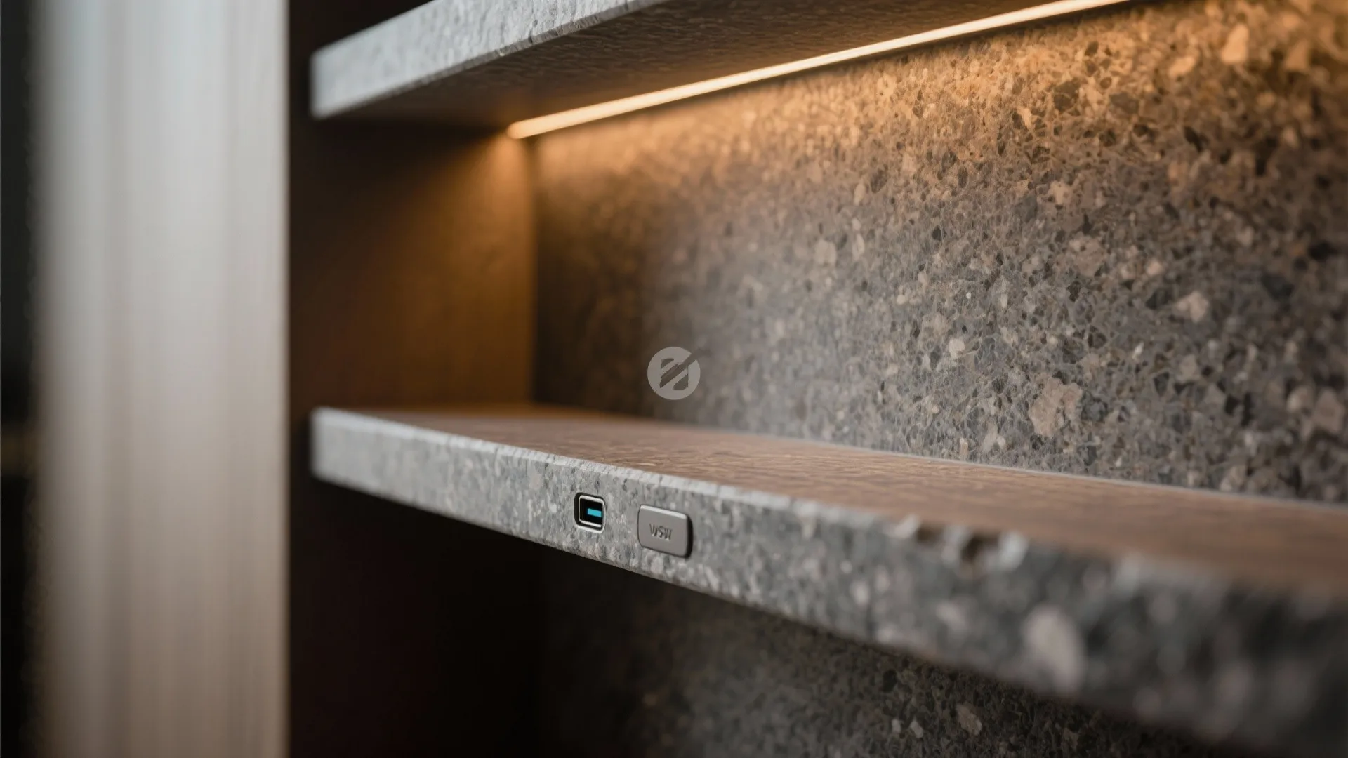Stone floating shelf with built in warm lighting and a power outlet on a textured wall