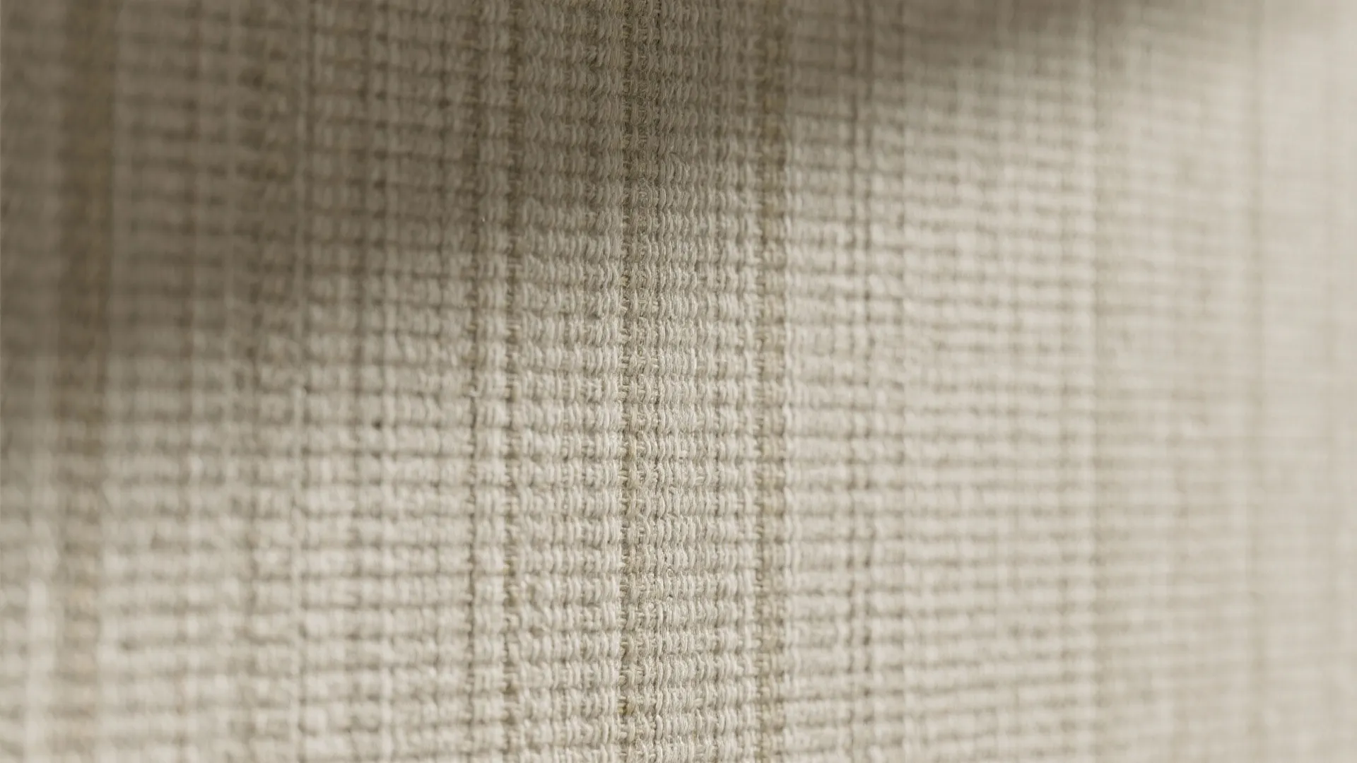 Close up view of natural woven fabric texture for wallpaper or upholstery in light beige color