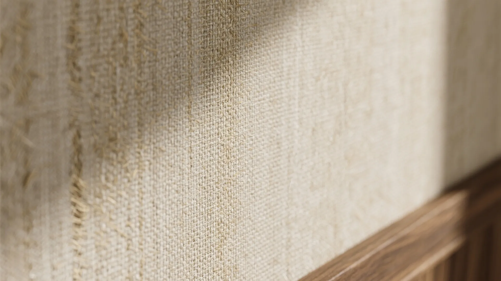 Macro detail of neutral grasscloth wallpaper with warm fibers and subtle tonal weave under soft daylight.