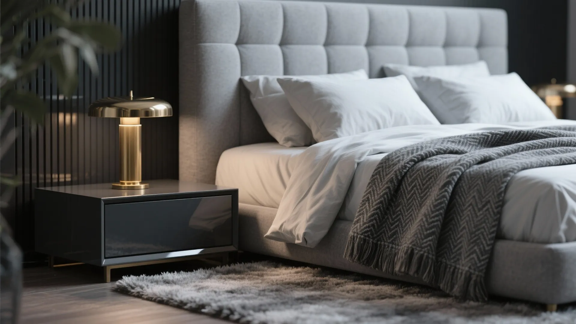 Close-up of gray headboard, glossy bedside table, wool rug and brass lamp showing layered textures