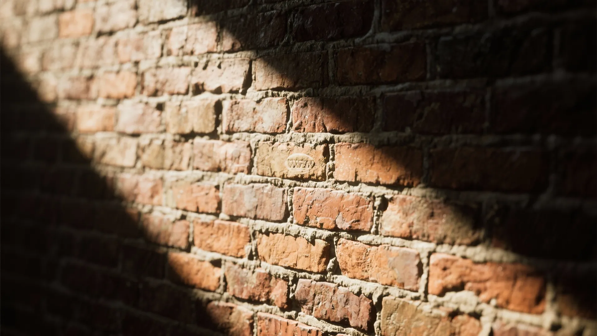 Close up view of red brick wall texture with bright sunlight creating shadows on the surface