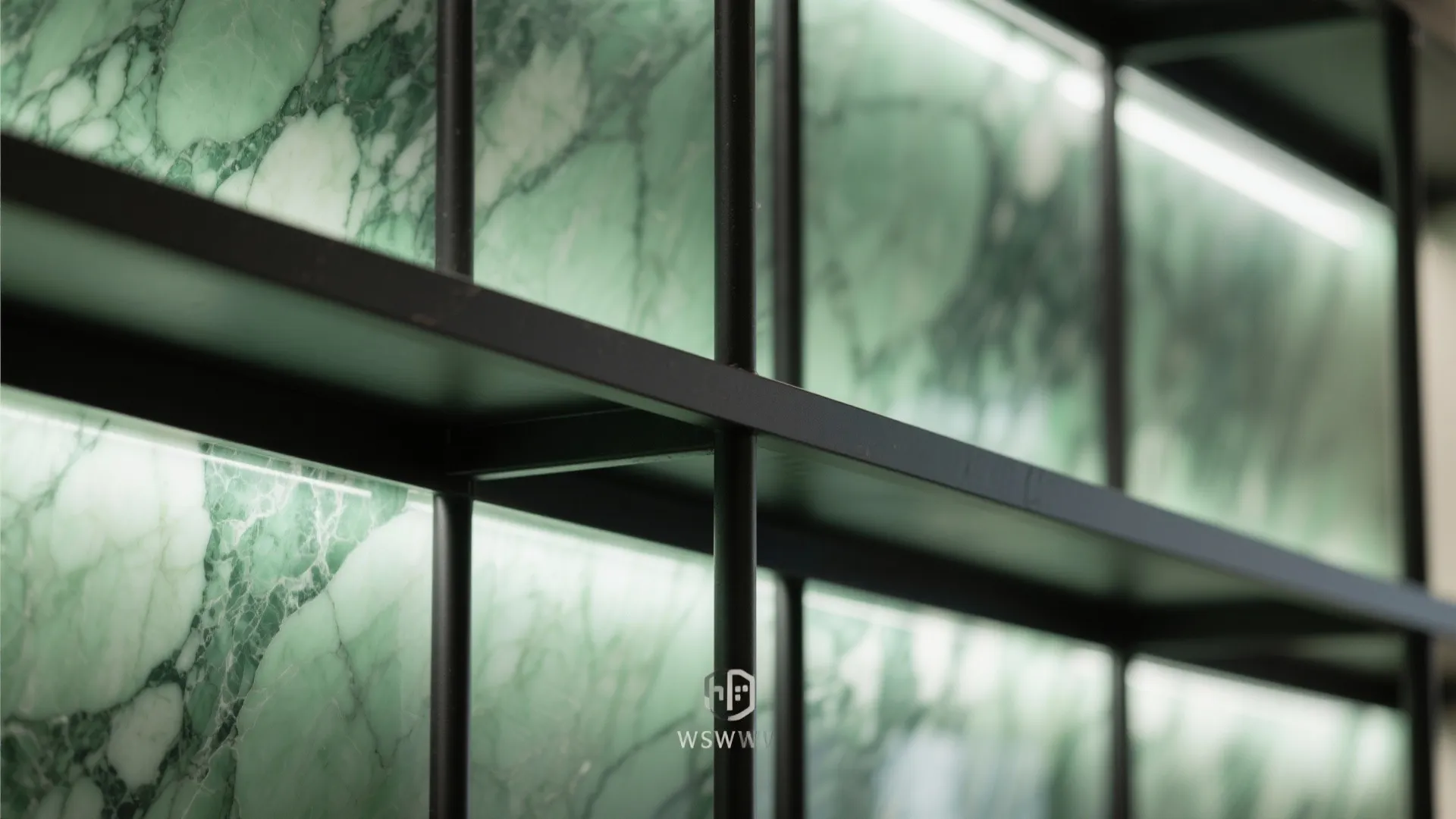 Close up view of green marble wall panels behind a black metal shelf with lighting