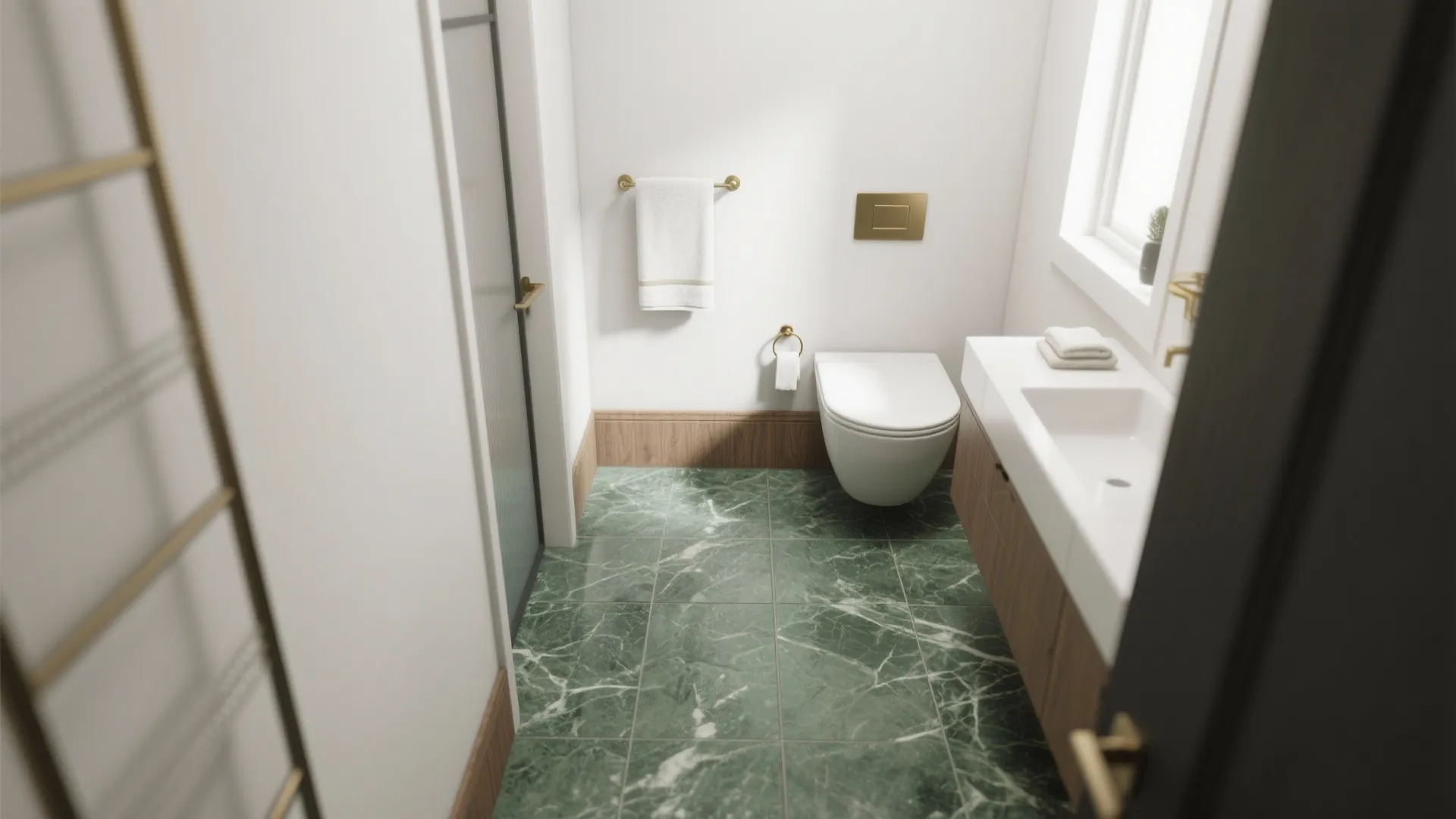 Compact bathroom showing honed green marble flooring with matte white walls and brass accents.
