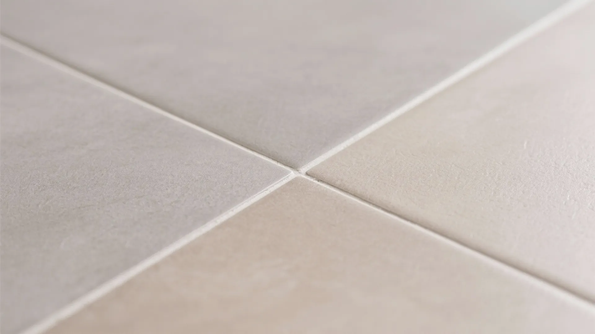 Close up view of neutral beige and grey floor tiles with clean white grout lines decoration