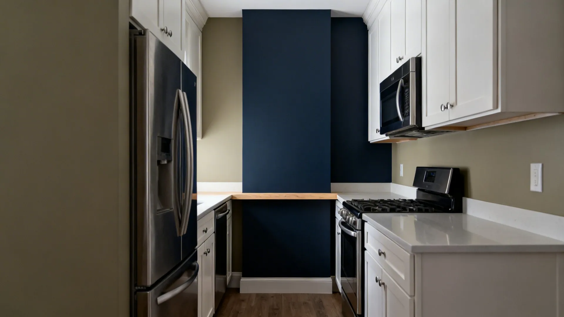 Greige long wall and deep navy accent wall shaping a refined galley kitchen with stainless accents.