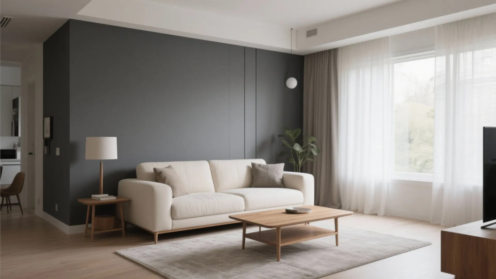 Minimalist living room featuring a grey accent wall cream sofa wooden coffee table and window