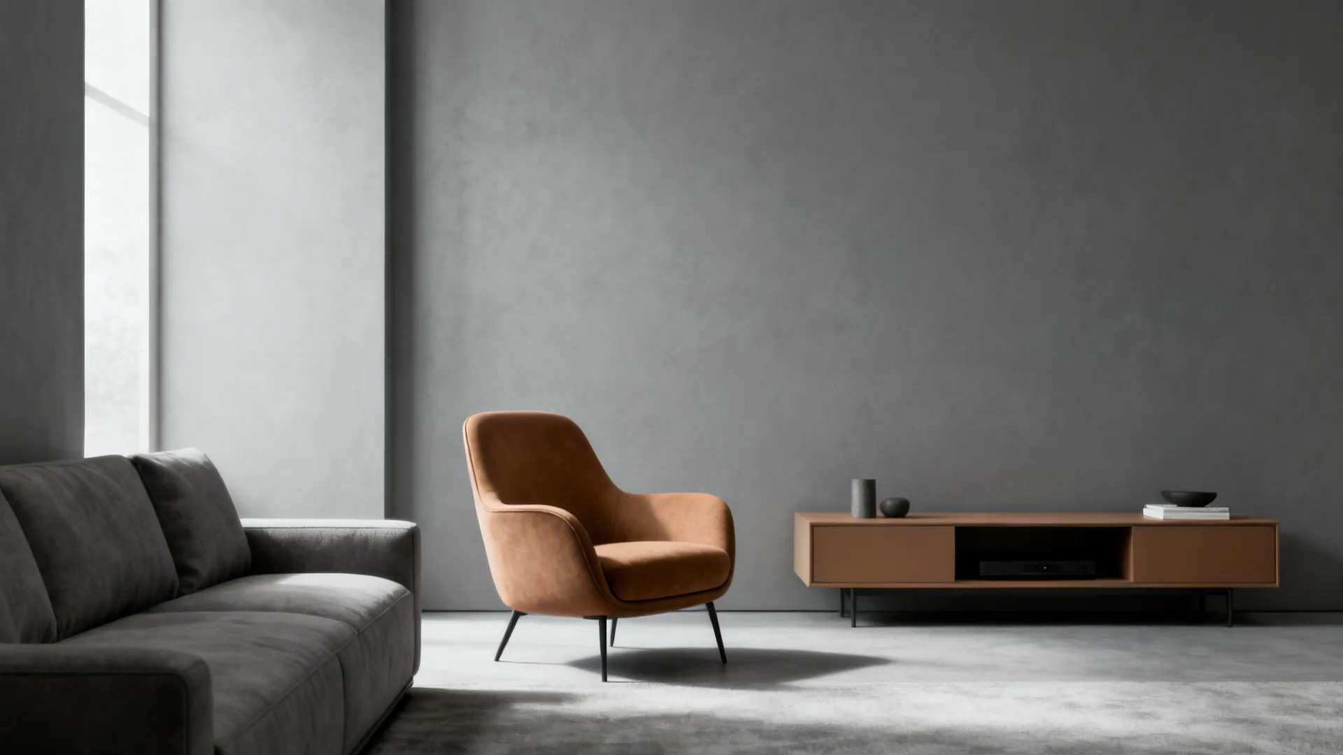 Minimalist living room with grey sofa tan armchair and low wooden cabinet against grey wall